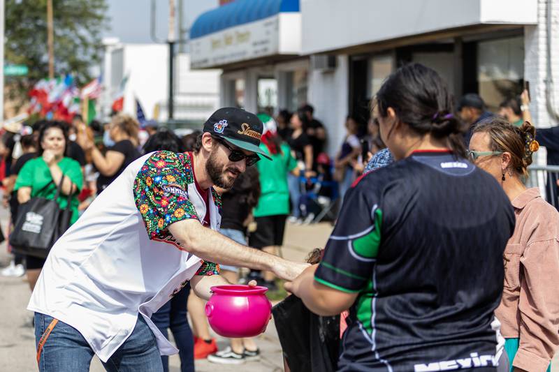 Joliet Slammers co-owner and Executive Vice President, Sales & Marketing, Night Train Veeck, hands out candy  during the City of Joliet Fiestas Patrias Mexican Independence Day Parade on Sept. 13, 2025.