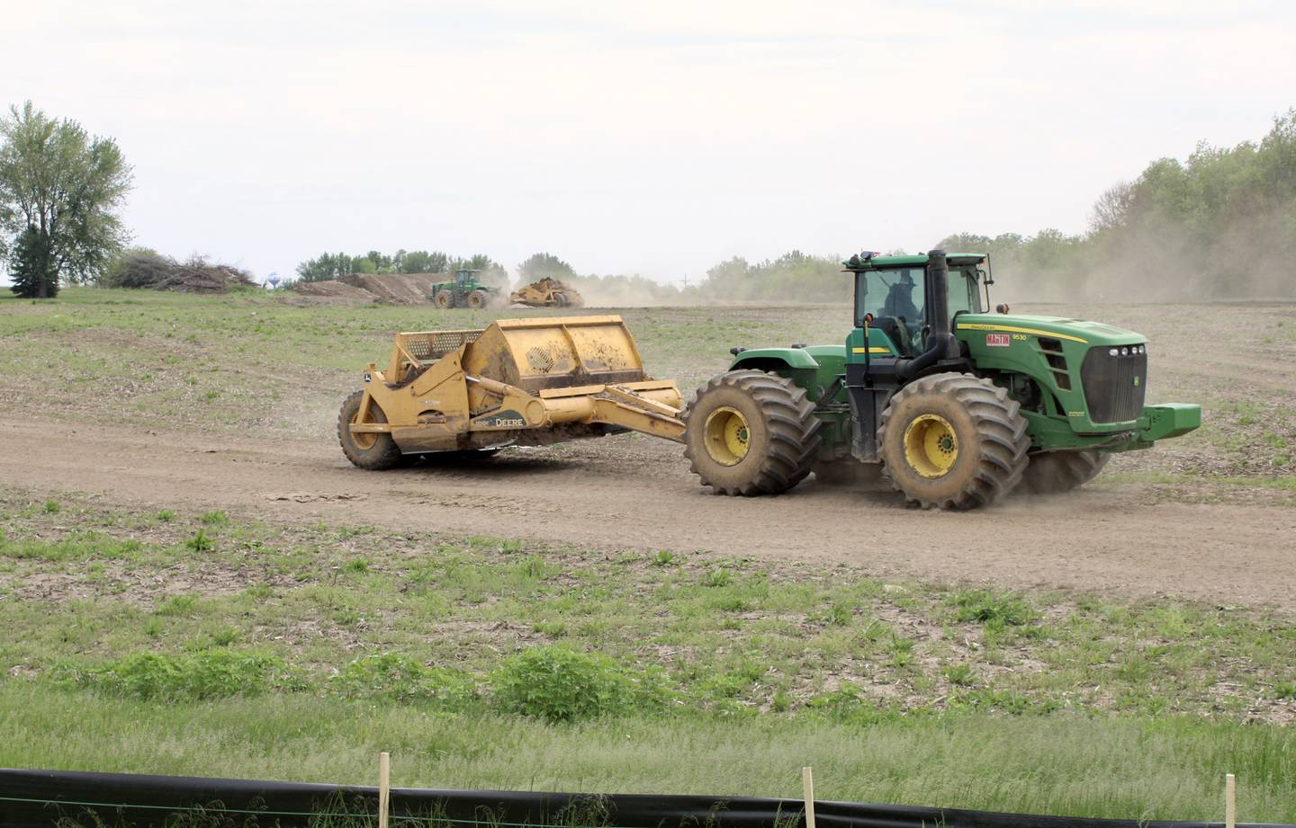 A tractor pulls a grade-leveling scraper over a section of the Dixon Gateway Project property near Illinois Route 26 and Keul Road on Tuesday. A groundbreaking for the project was April 28. The Gateway Project will bring a new hotel, gas station, restaurants and shops on 27 acres.