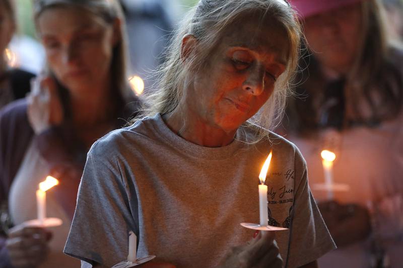 Jackie Teuerle holds a candle as “Amazing Grace” is song during a candlelight celebration for her son, Riely Teuerle, on Thursday, August 11, 2022, at Towne Park, 100 Jefferson Street in Algonquin. Teuerle was killed in a car crash in Lake in the Hills on Tuesday. Over 100 family members and friends gathered at the park to remember and celebrate Teuerle’s life.