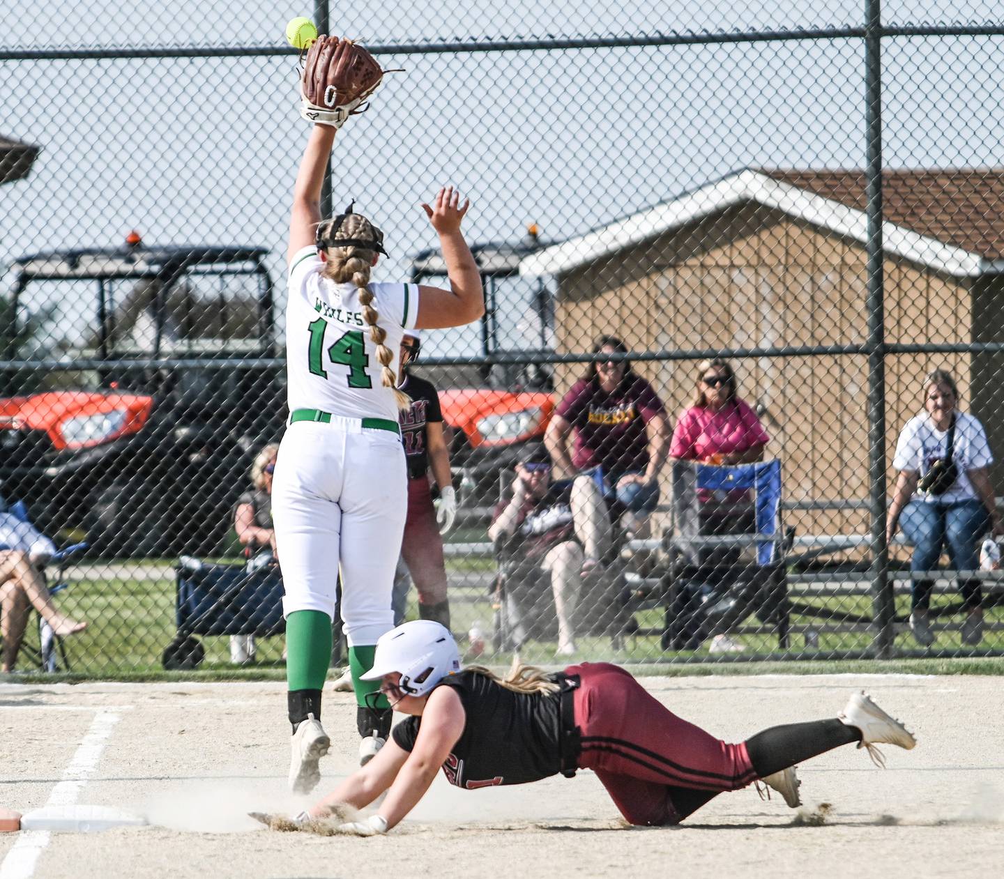 Richmond Burton's Lyndsay Reginier dives back to first on a high throw to Rock Falls firstbasman Abby Whiles during sectional semifinal action Tuesday.