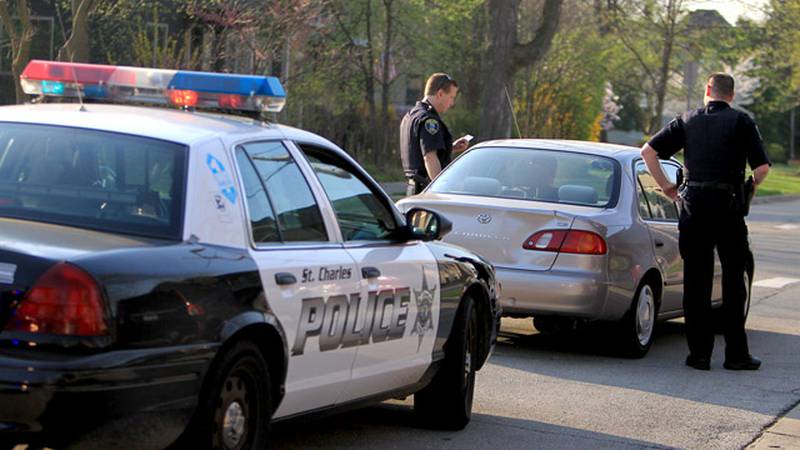 Officer Dave Ketelsen (left) and officer Rich Clark of the St. Charles Police Department stop a driver near Lincoln School in St. Charles for using a cellphone in a school zone Wednesday.