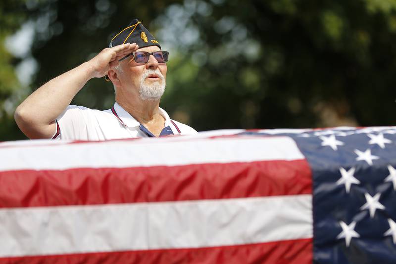 American Legion Post 171 Commander Charlie Morgan salutes the flag as Dana Robinson sings the National Anthem during a Patriots Day remembrance for the 20th anniversary of the terrorist attacks of 9/11 on Saturday, Sept. 11, 2021 at Union Cemetery in Crystal Lake.