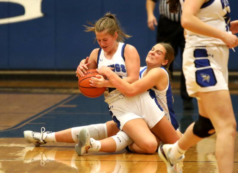 Geneva’s Caroline Madden (left) and Wheaton North’s Zoey Bohmer battle for a loose ball during a game at Geneva on Friday, Dec. 22, 2023.