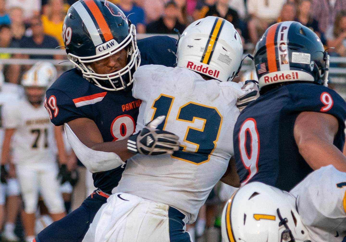 Taiden Thomas (89) of Oswego hits Mark Mennecke (13) of Neuqua Valley in the backfield for a loss in a football game at Oswego High School on Friday August 26, 2022.