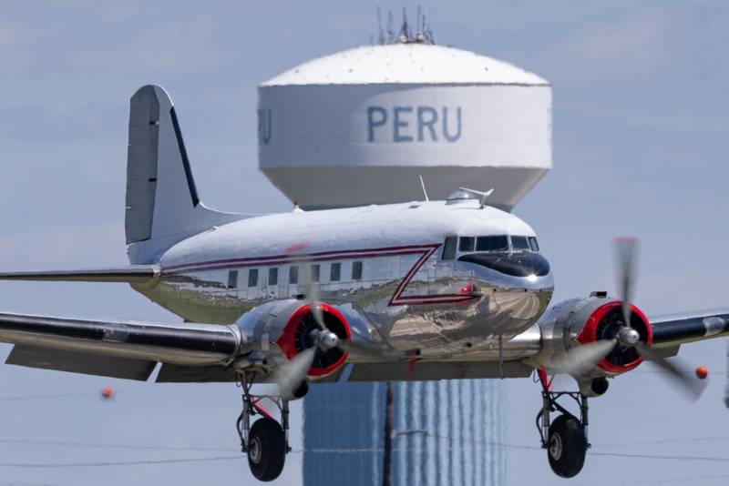 A Douglas DC-3 passes in front of the Peru water tower on the landing approach during the 10th annual TBM Avenger Reunion and Airshow on Saturday, May 17, 2025 at the Illinois Valley Regional Airport in Peru.
