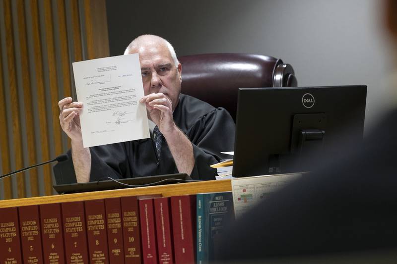 Whiteside County Circuit Court Judge James Heuerman displays a form Thursday, May 22, 2025, during Kyle Cooper's plea deal hearing at the Whiteside County Courthouse in Morrison.