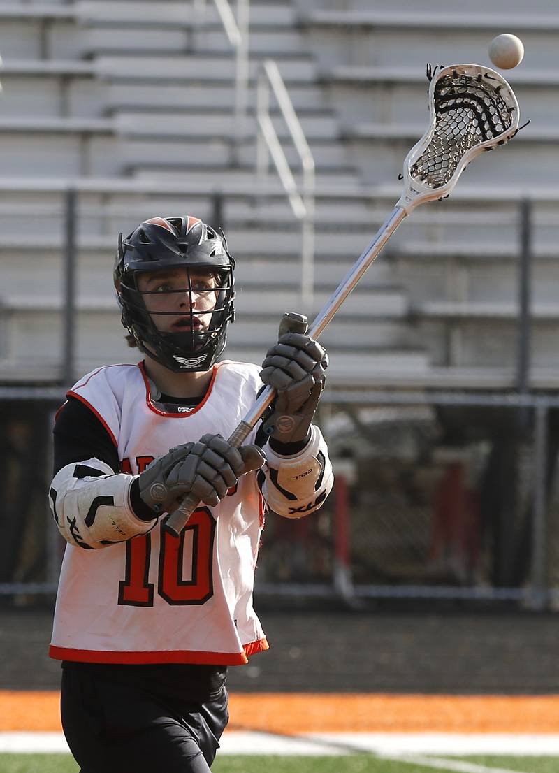 A McHenry lacrosse player Dom Caruso passes the ball to a teammate while doing passing drills during lacrosse practice Wednesday, March 8, 2023, at McCraken Field in McHenry.