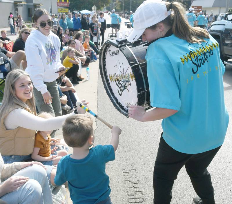 Connor Ware, 3, of Oregon, was given a chance to bang one of the drums of the Crystal Lake Strikers Drum Line during the Harvest Time Parade at the Autumn on Parade festival in Oregon on Sunday.