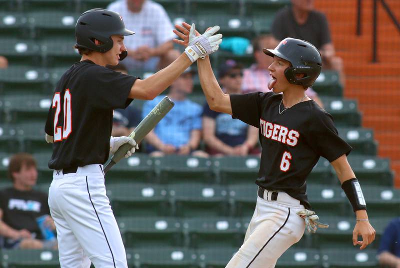 Crystal Lake Central’s John Dobbeck, right, is greeted by Wade Ozment after coming around to score in supersectional baseball action against DePaul College Prep at Wintrust Field in Schaumburg Monday.