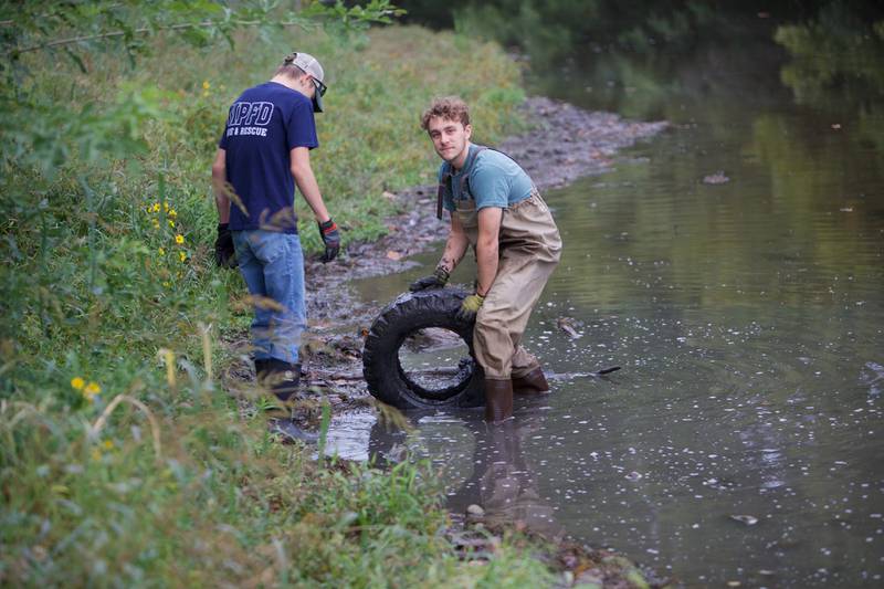 Volunteers pull a tire out during the Fox River cleanup event at Fearson Creek Park on Saturday, Sept. 16,2023 in St. Charles.