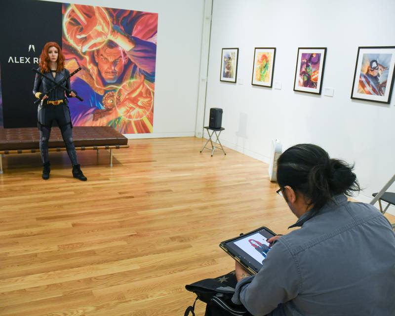 Archangelo Crelencia of Chicago draws the Black Widow portrayed by Lisa J. during a live model demonstration during The Marvelcity: The Art of Alex Ross held at the Elmhurst Museum on Saturday June 24, 2023.