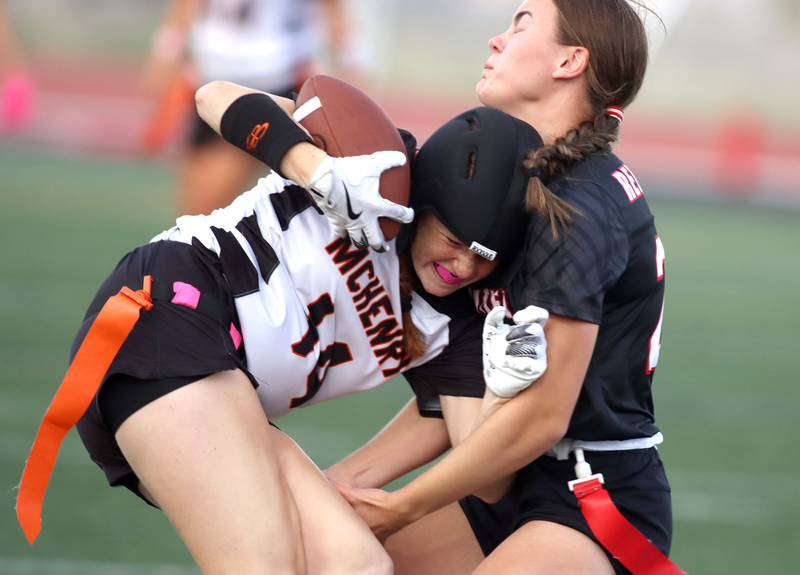 McHenry’s Morgan Frederick, left, is stopped by Huntley’s Aubrie Rohrbacher in varsity flag football at Huntley High School in Huntley on Tuesday, Sept. 9, 2025.