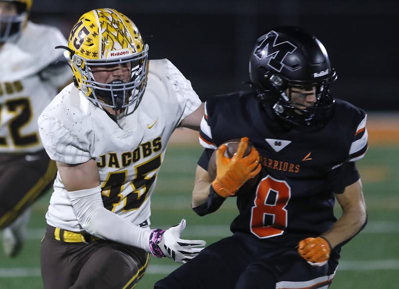 McHenry's Jeffry Schwab tries to spin away from Jacobs' John Coates as he returns a kick during a Fox Valley Conference football game on Friday, Oct. 18, 2024, at McCracken Field in McHenry.