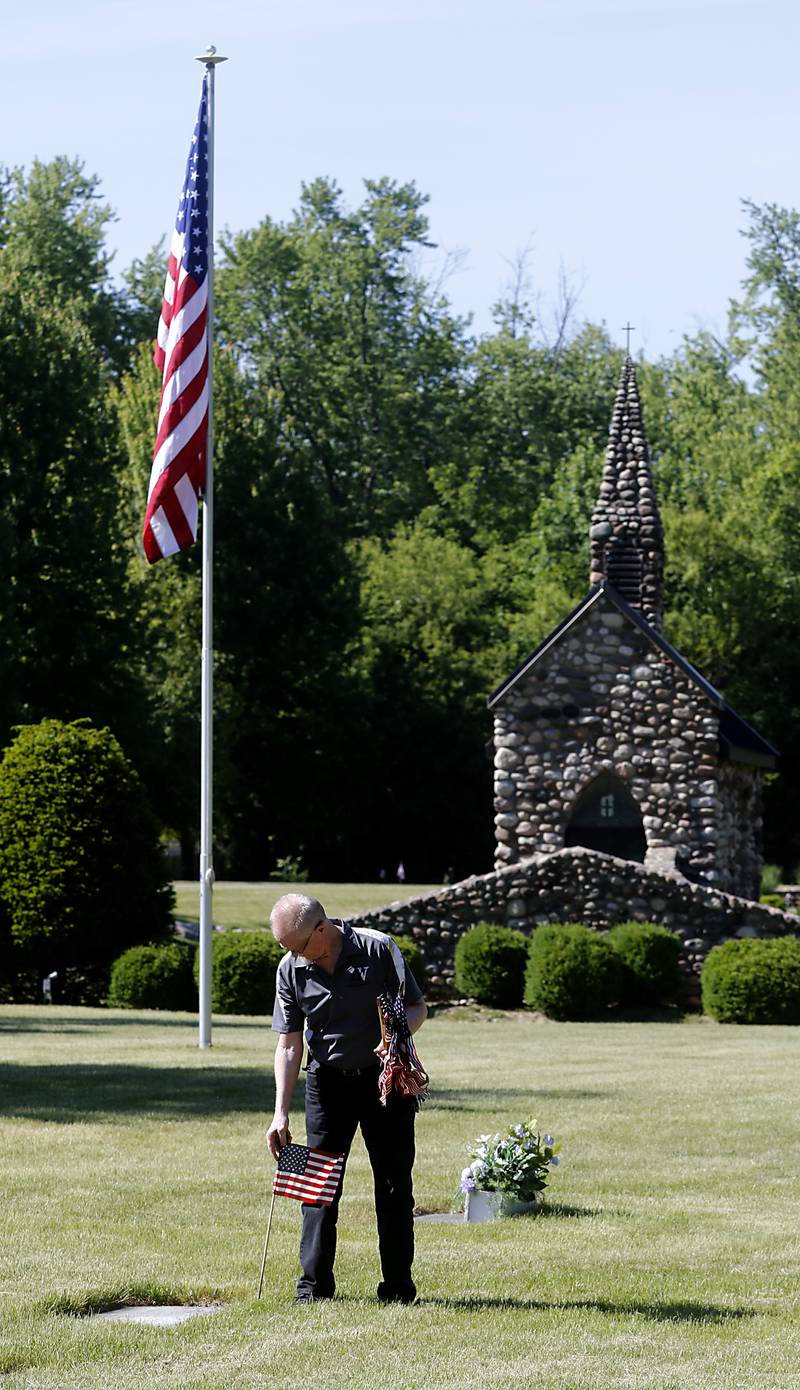 U.S. Army veteran Alex Januk  places flag at veterans gravesite as volunteers help former members of Johnsburg VFW Post 11496, which recently merged with Lake Villa VFW Post 4308, place flags on Friday, May 26, 2023, at the graves of over 150 veterans in St. John the Baptist Cemetery, in Johnsburg.