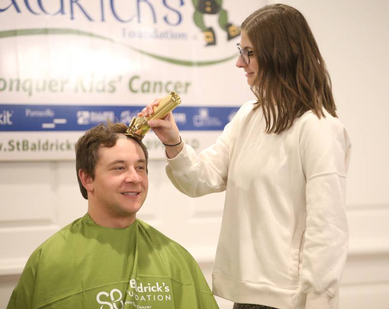 Utica firefighter Koty Gapinski, has his head shaved by his wife Hannah during the 18th annual Illinois Valley Emergency Services St. Baldrick's event on Sunday, March 23, 2025 at Senicas Oak Ridge in La Salle.