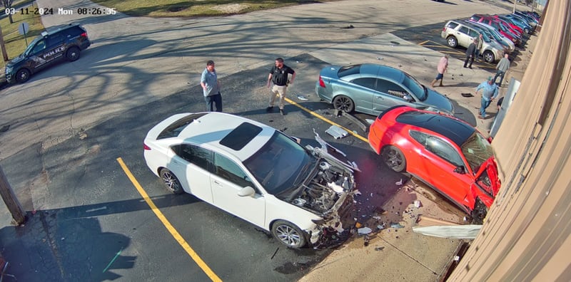 Police said a man driving the red car crashed into a business' building in Harvard, striking the two other cars as well.