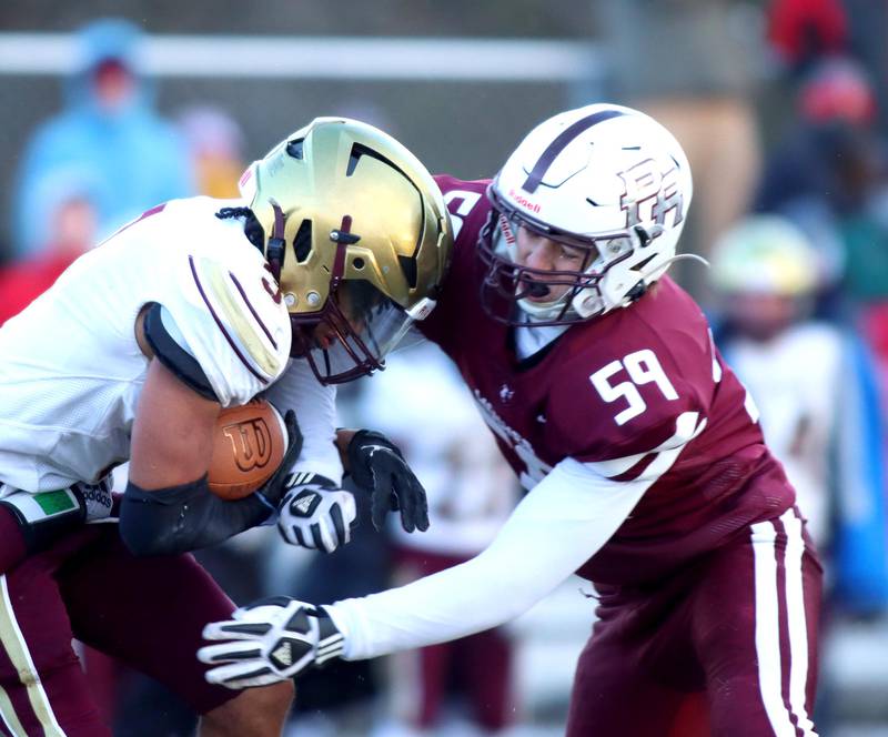 Prairie Ridge’s Jace Kranig, right, closes in on St. Ignatius’ John Kemp in Class 6A football playoff semifinal action at Crystal Lake on Saturday.