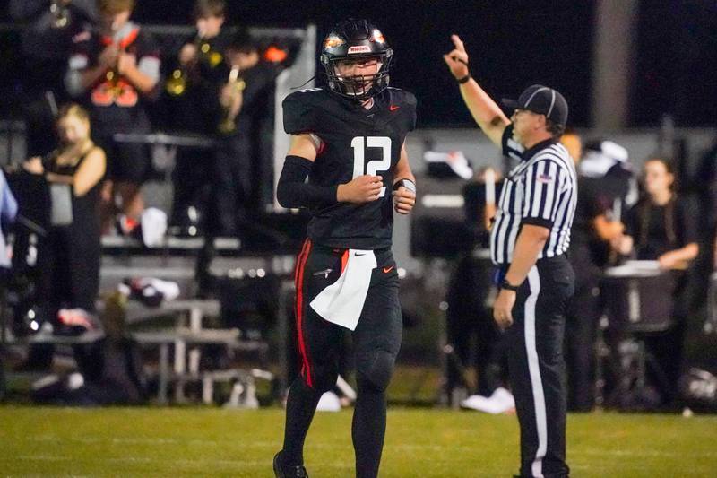 Sandwich Quarterback Brady Behringer (12) looks at the score board as he makes his way to the sideline during a football game against Woodstock at Sandwich High School on Friday, Oct. 11, 2024.