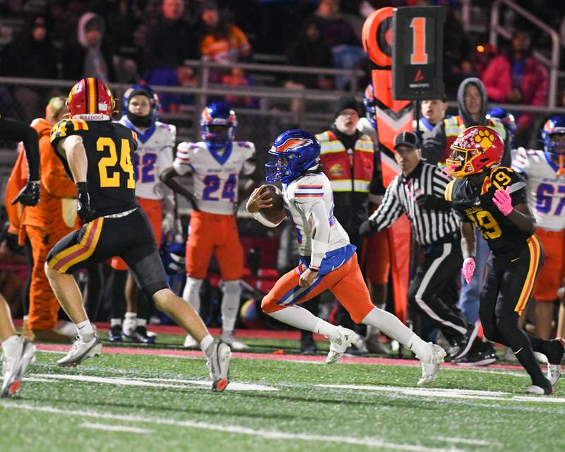 Hoffman Estates's Landon Ford (28) runs the ball while being defended by Batavia players during the first round of playoffs on Friday Oct. 31, 2025, held at Batavia High School.