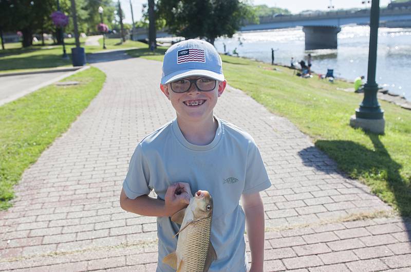 Owen Dempsey, 9, of Dixon proudly displays a 2.2 pound carp he reeled in out of the Rock River during the fishing derby Saturday, July 2, 2022.