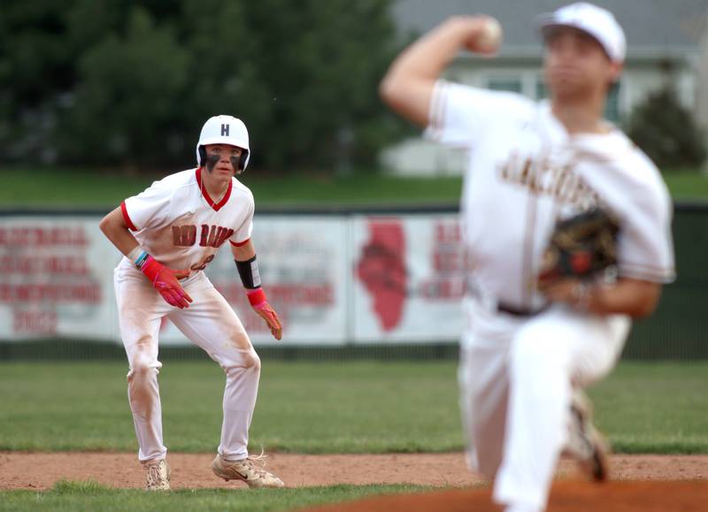Huntley’s Kyle Larson, left, moves with the offering from Jacobs’ Justin Ceisel in varsity baseball Wednesday at Huntley.