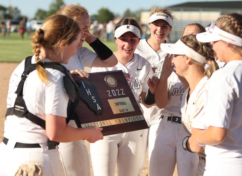 Kaneland catcher Corinne Pugh brings the sectional trophy to her team after defeating Belvedere North Friday, June 3, 2022, in the IHSA Class 3A Sectional final game at Sycamore High School.