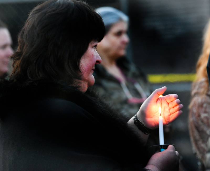 Kim Caponi of Morris, holds a candle for her relative Marlana McFarland during a vigil on Tuesday night. McFarland was electrocuted while trying to help her neighbors after a power line fell on their home on Saturday.
