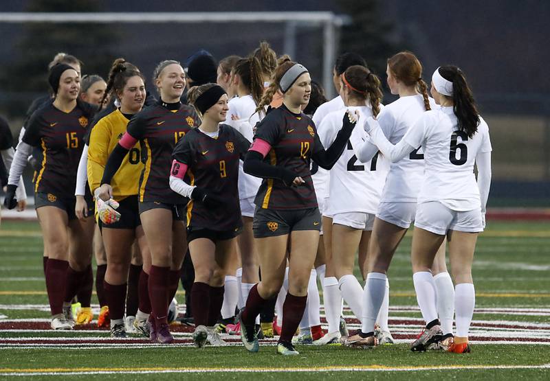 The teams high five each other before the start of a non-conference girls soccer match Thursday, March 16, 2023, at Richmond-Burton High. McHenry defeated Richmond Burton 4-0, in the first game of the season for both teams.