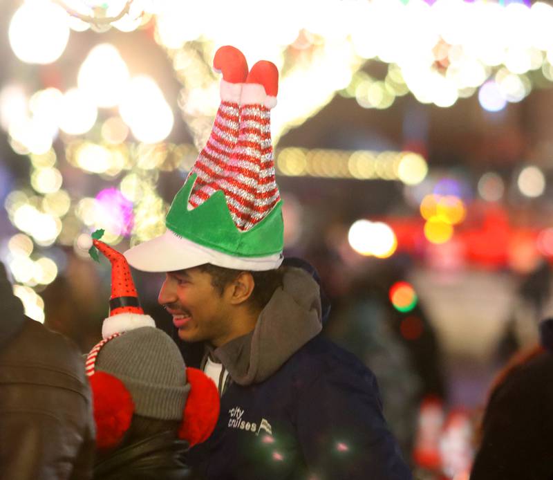 Darin Robinson of Chicago watches the the Festival of Lights Holiday Parade in downtown Crystal Lake with others on Friday, Nov. 29, 2024.