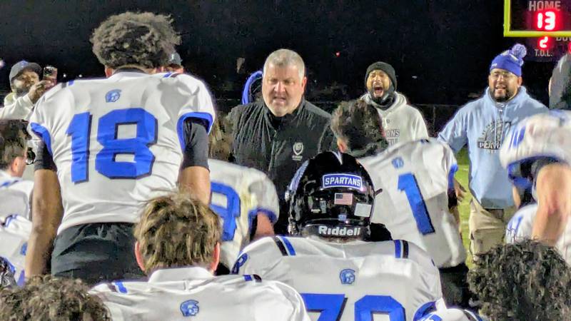 St. Francis coach Bob McMillen celebrates with his players after his team's 35-13 win against Belvidere North in a Class 5A semifinal on Saturday, November 22, 2025.