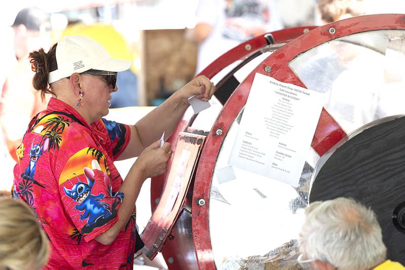 The cars get them there, the giant pot of cash keeps ‘em coming back for the annual Depot Days car show and 50/50 drawing in Amboy. Billie Winters of Dixon chucks her tickets into the drum Sunday, Aug. 25, 2024, to try her luck at the pot.
