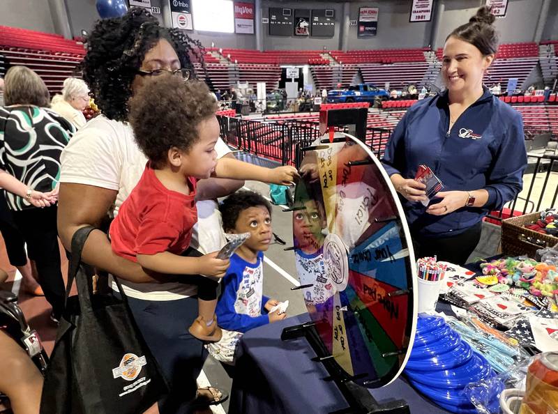 David Holliday Jr., age 2, from DeKalb, spins the prize wheel Thursday, April 23, 2026, at one of the booths during the DeKalb Chamber of Commerce Local Showcase in the Convocation Center at Northern Illinois University in DeKalb.