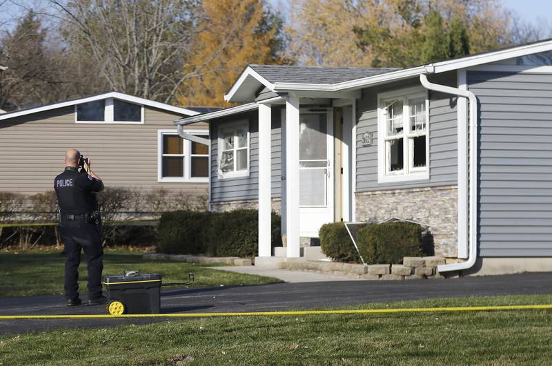 A Johnsburg police officer photographs damages to a home in the 3600 block of Fillmore Road on Wednesday, Nov, 15, 2023. Johnsburg Police officers were dispatched to the home at approximately 11:08 p.m. Tuesday, for a man allegedly shooting a gun inside the house.