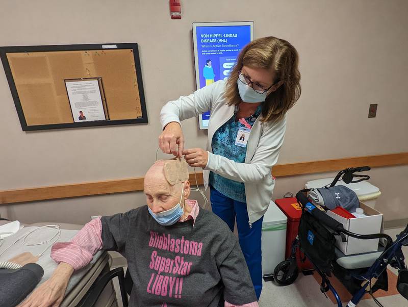 Joan Quaresima, a radiation oncology nurse at Joliet Oncology-Hematology Associates, applies transducer arrays to the scalp of Libby Hall, 75, of Joliet, on Friday, Sept. 16, 2022. Hall was diagnosed with glioblastoma multiform, an aggressive brain cancer, in 2020 and is currently wearing a device called Optune, which delivers an electrical field into the cancer cells in her brain.