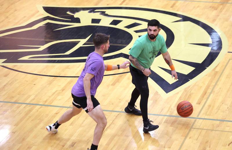 The Fire/Police team member Ryan Nicholson dribbles the ball up court against Sycamore School Staff team member Michael Buckner play Thursday, Dec. 19, 2024, during the Heroes on Hardwood basketball game at Sycamore High School. The basketball game, which is a fundraiser for the Sycamore Food Pantry, pits a team of Sycamore first responders against a squad of Sycamore School District 427 staff.