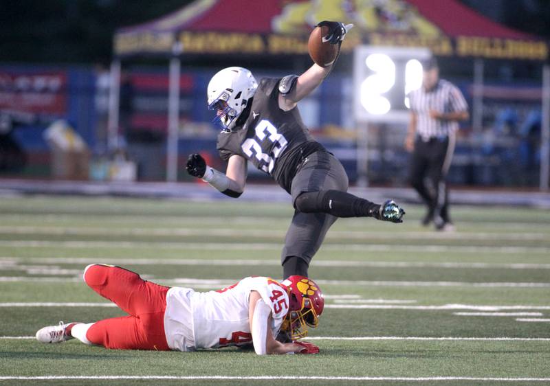 St. Charles North’s Jake Furtney (right) holds onto the ball over a tackle by Batavia’s Drew DiBiase during a game at St. Charles North on Friday, Sept. 15, 2023.