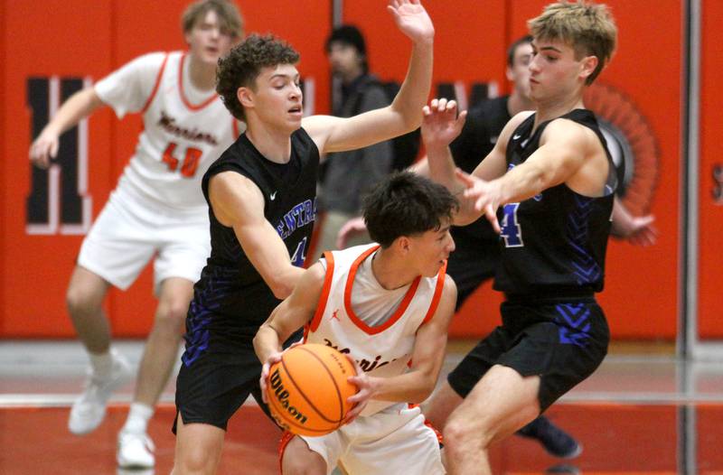 McHenry’s Cole Tapia looks for an options as Burlington Central’s Ryan Carpenter, left and Bennek Braden, right, double team coverage in varsity boys basketball on Friday, Dec. 5, 2025, at McHenry Community High School in McHenry.