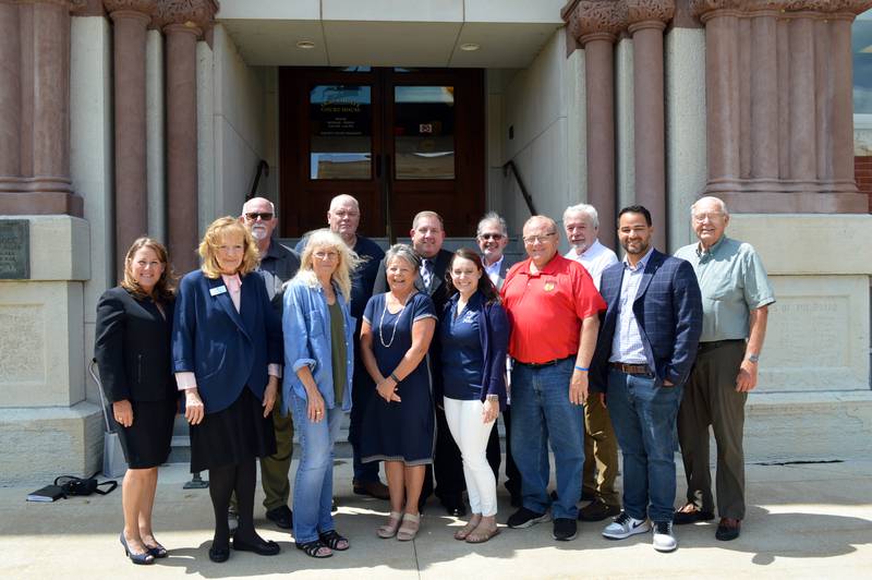 Ogle County Economic Development Corporation officers and other interested parties pose for a photo outside the Old Ogle County Courthouse on Aug. 17, 2023. Front row, left to right: ComEd Economic and Business Development Team member Karen Halstead; Comcast Government and Community Affairs manager Joan Sage; Ogle County Board Vice Chairperson Patricia Nordman; OCEDC Secretary and Mt. Morris EDC Executive Director Paula Diehl; Polo City Clerk Sydney Bartelt; Stillman Valley Village President Marty Typer; and ComEd External Affairs manager Nicolas Escobar. Back row, left to right: OCEDC Treasurer and Byron Mayor John Rickard; OCEDC President and Polo City Councilperson Randy Schoon; OCEDC Vice President and Oregon City Manager Darin DeHaan; OCEDC economic development consultant Chris Manheim; Oregon Mayor Ken Williams; and Ogle County Board Chairperson John Finfrock.