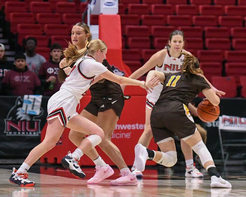 Northern Illinois University's Lexi Carlsen, center, tries to defend Western Michigan University's Megan Wagner (11) but gets fouled by western Michigan University's Eveyn Carrier (23) during the game on Saturday Jan. 11, 2025, held at the Convocation Center in DeKalb.