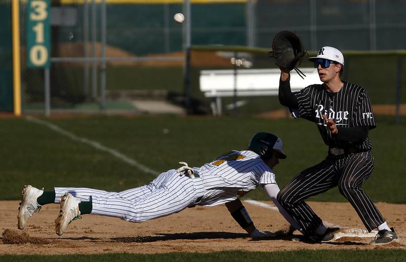 Crystal Lake South’s C.J. Regillo dives back to first base in front of the throw to Prairie Ridge's Karson Stiefer during a Fox Valley Conference baseball game on Monday, April 8, 2024, at Crystal Lake South High School.