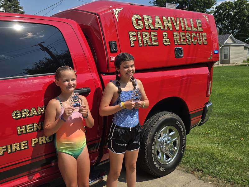 (From left) Zoee Weeks (second) and Emily Konczak (first) show off their water fight trophies Saturday, Aug. 3, 2024, during Granville Days at Hopkins Park.
