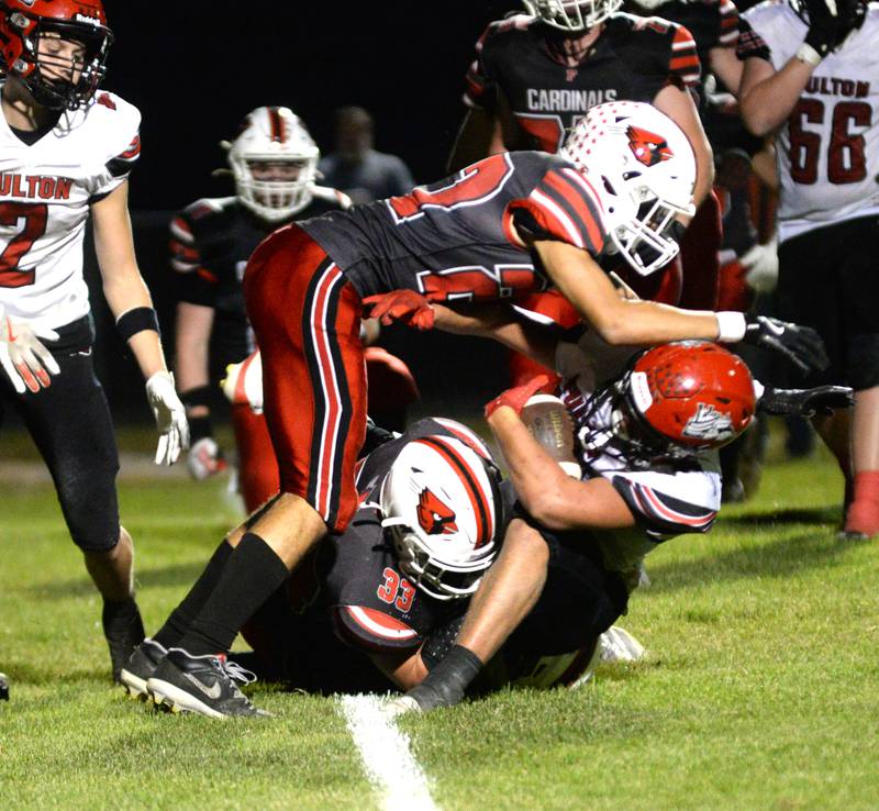 Forreston defenders Lucas Miller (22) and Christopher Rohdy (33) tackle a Fulton runner during NUIC action in Forreston on Friday, Sept. 12, 2025.