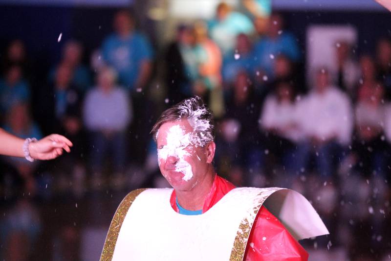 Tim Racki, dean of students and head football coach at Nazareth Academy, gets a pie to his face during a homecoming pep rally at the La Grange Park school on Friday, Sept. 29, 2023.