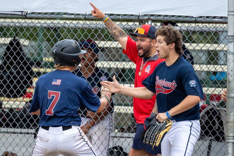 Jake Edlund (7) of Illinois celebrates scoring run with Coach Enrique Villanueva and Lucas Karczewski (11) on Thursday, July 17, 2025 at Washington Park in Peru.