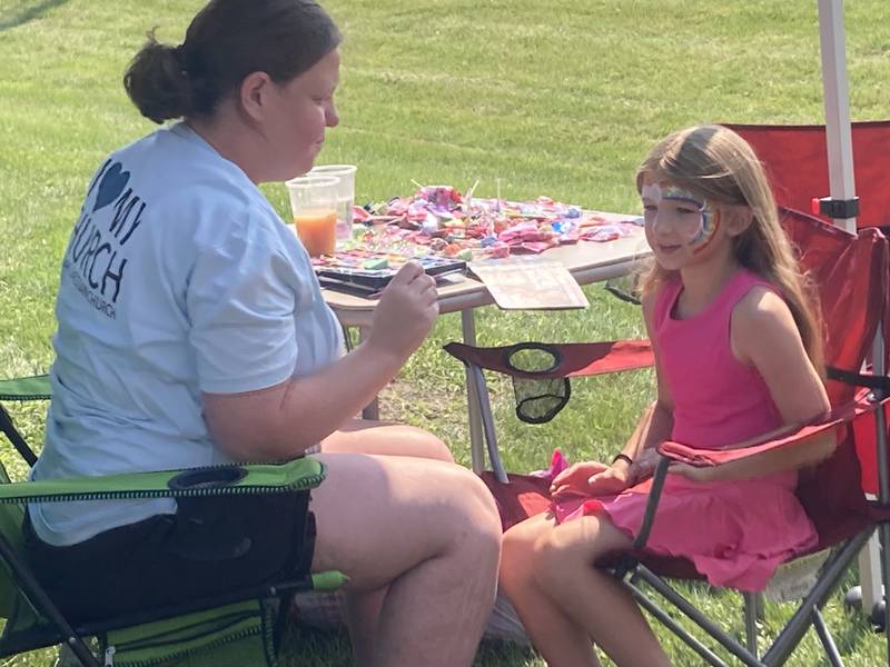 A volunteer paints the face of a young attendee at the Shorewood Crossroads Festival on Saturday, August 2, 2025.