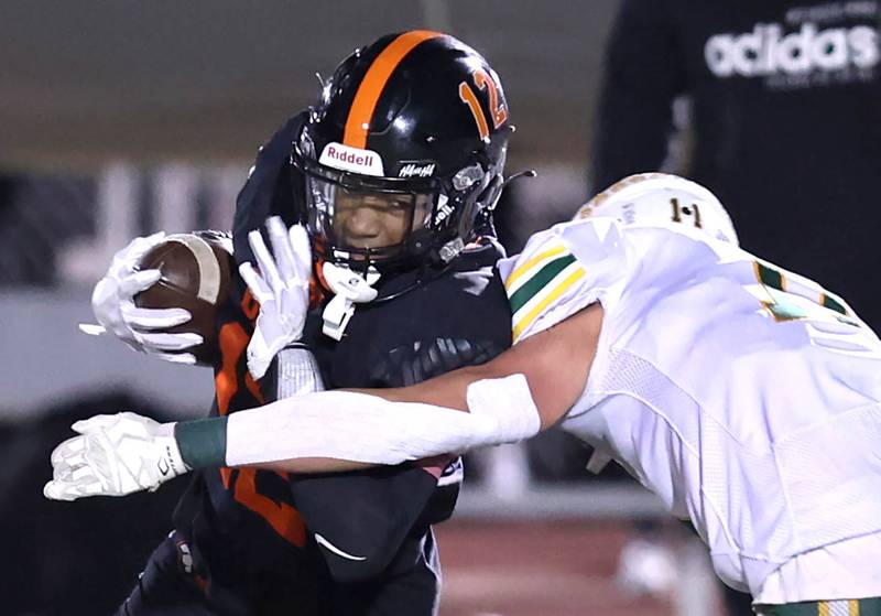 DeKalb's Ethan McCarter is hit by Waubonsie Valley's Bryce Provis after a catch during their game Thursday, Oct. 20, 2022, at DeKalb High School.