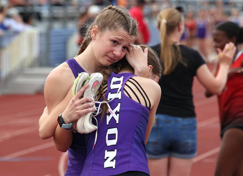 Dixon Runners embrace after the finish of the 4x800 relay Wednesday, May 8, 2024, during the girls track Class 2A sectional at Rochelle High School.