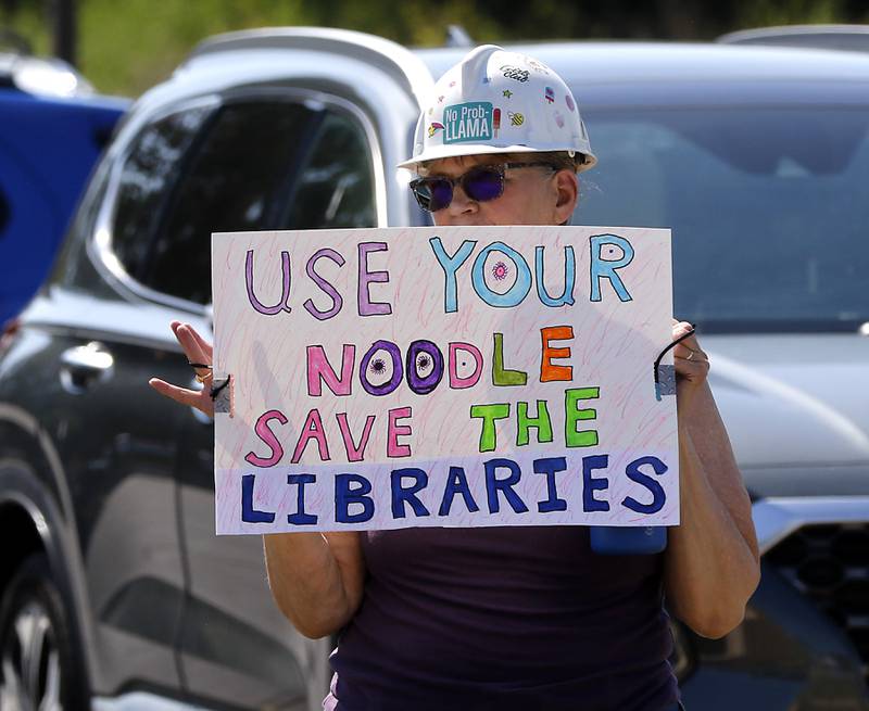 Tina Uselding protests along Route 31 in front of the McHenry Public Library on Friday, June 20, 2025, during a Save Our Libraries Protest hosted by Indivisible McHenry County to draw attention to cuts to the nation’s libraries by the Trump administration.