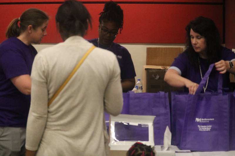 Volunteers from Northwestern Medicine assist a resident on Friday, May 31, 2024, during a donation and collection event held in support of the dozens of DeKalb residents displaced by the Husky Ridge Apartment fire that damaged all 12 units inside the building on May 29, 2024.