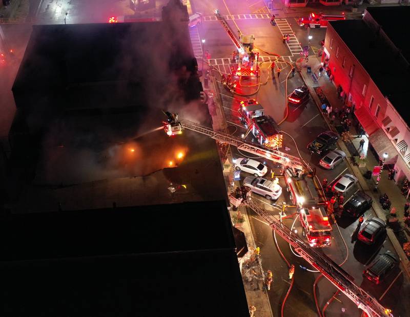 Multiple fire departments from Peru, Spring Valley, Princeton and Mendota use aerial ladder trucks to attack the flames on top of a building at 708 Illinois Avenue on Friday, Dec. 29, 2022 in Mendota. A three-alarm fire summoned fire departments from La Salle and Bureau Counties. The fire occurred shortly after 9p.m. in the second story of the building.